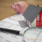 white and red wooden house beside grey framed magnifying glass